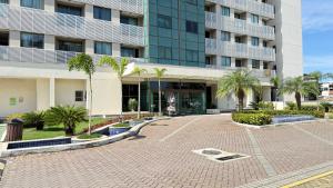 a building with a courtyard with palm trees in front of it at Flat das Montanhas in Rio de Janeiro