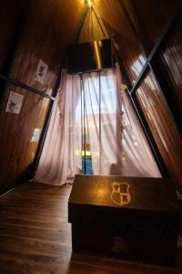 a room with a window and a chest in a attic at Lumos Experience in Guaratuba