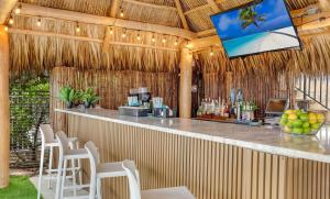 a bar in a resort with a television above it at Oceanview Apt Marenas Resort, Direct Beach Access! in Sunny Isles Beach