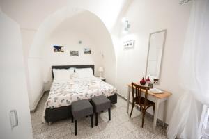 a bedroom with a bed and a table and a mirror at Chiarina rooms in Polignano a Mare