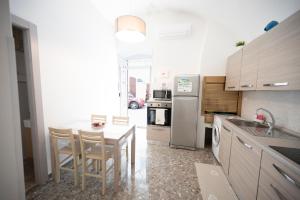a kitchen with a table and chairs and a refrigerator at Chiarina rooms in Polignano a Mare