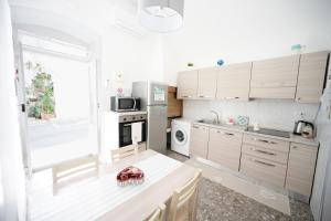 a kitchen with white cabinets and a counter top at Chiarina rooms in Polignano a Mare +7 photos