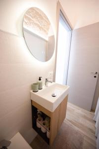 a bathroom with a white sink and a mirror at Chiarina rooms in Polignano a Mare