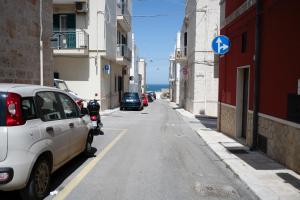 a white car parked on the side of a street at Chiarina rooms in Polignano a Mare