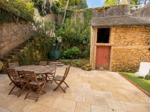 a patio with a table and chairs and a building at Le loft de l'entrepote in Argenton-sur-Creuse