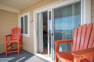 two chairs sitting on the porch of a house at Captains Choice by Oak Island Accommodations in Caswell Beach