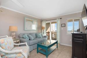 a living room with a couch and a table at Captains Choice by Oak Island Accommodations in Caswell Beach +78 photos