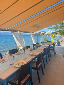 a long table with chairs and the ocean in the background at Villa art colony in Ohrid