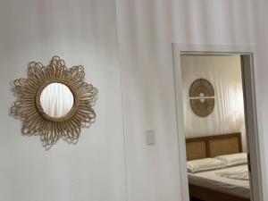 a mirror on a wall next to a bedroom at Palm Paradise Apartaments in Golem