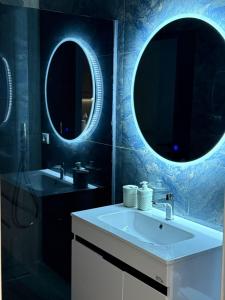 a bathroom with two sinks and two mirrors at Palm Paradise Apartaments in Golem