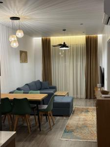 a living room with a blue couch and a table at Palm Paradise Apartaments in Golem
