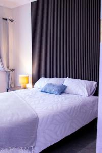 a bed with white sheets and pillows in a bedroom at WN Apartments in Lusaka