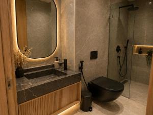 a bathroom with a black toilet and a sink at Maarif appartement moderne in Casablanca +8 photos