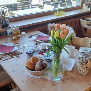 a table with a vase of flowers and bread at Brend Hotel und Gasthof in Furtwangen