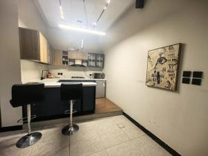 a kitchen with two bar stools in a room at Welcome to Chalet Bonsiana! in Jeddah