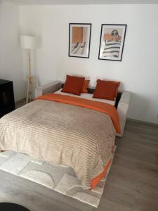 a bedroom with a large bed with an orange blanket at Appartement chez pépite in Namur