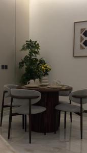 a table with chairs and a potted plant on it at شقة بغرفتين نوم وصالة in Hail +14 photos