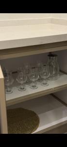 a row of wine glasses sitting on a shelf at شقة بغرفتين نوم وصالة in Hail