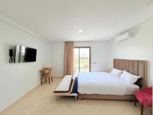 a bedroom with a bed and a tv on a wall at Stay with US in Agadir