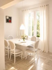 a white dining room with a white table and chairs at Relax Villa with Pool in Bihać
