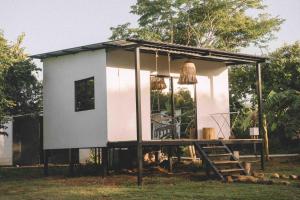 a tiny house with a porch and a staircase at Alma Vita Punta Mango in Jucuarán