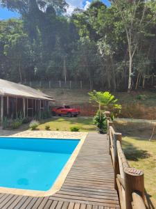 a wooden walkway leading to a house with a pool at Chácara Pé da mata itajuba mg in Itajubá +3 photos