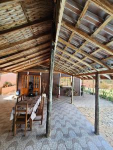 a patio with a table and chairs under a wooden ceiling at Chácara Pé da mata itajuba mg in Itajubá