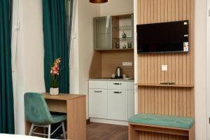 ein kleines Zimmer mit Schreibtisch und kleiner Küche in der Unterkunft Mersa Hotel in Backnang