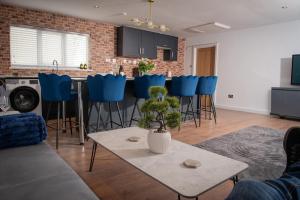 a living room with a table and blue bar stools at Easterly Sleeps in Lowestoft