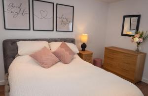 a bedroom with a white bed with three pillows at Easterly Sleeps in Lowestoft