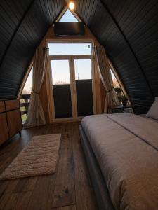 a bedroom with a bed and a large window at Lake House Jeziorsko in Ostrów Warcki +20 photos