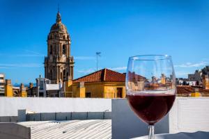 a glass of wine sitting on a ledge with a building at Ohana Urban Málaga Centro in Málaga +3 photos