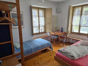 a bedroom with a bunk bed and a table at Garni Cà Stella in Bignasco