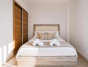 a bedroom with a large bed with two pillows at Ohana Urban Málaga Centro in Málaga