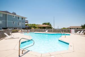 a large swimming pool with chairs at Castaway by Oak Island Accommodations in Caswell Beach +68 photos