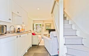 a kitchen and living room with a staircase in a house at Cosy Llangattock Hideaway in Crickhowell