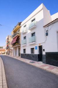 an empty street in front of a white building at Ohana Urban Málaga Centro in Málaga