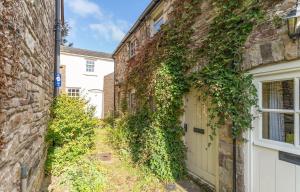 an ivy covered building with a white door at Cosy Llangattock Hideaway in Crickhowell
