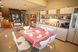 a kitchen with a red and white table and chairs at Del Nomade Hosteria Ecologica in Puerto Pirámides +22 photos