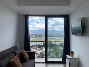 a living room with a couch and a large window at Inara 2 - Apartment with airport views - Zona 13 de la Ciudad de Guatemala in Estación Pamplona