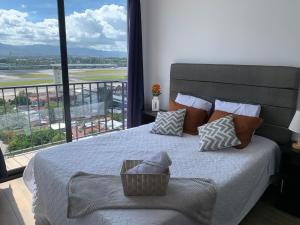 a bedroom with a bed with a view of an airport at Inara 2 - Apartment with airport views - Zona 13 de la Ciudad de Guatemala in Estación Pamplona