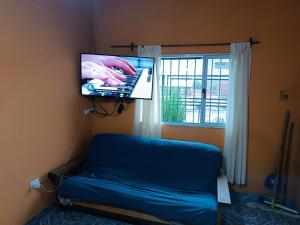 a room with a bed and a tv and a window at Hospedaje Algo Nuestro in Gobernador Gregores