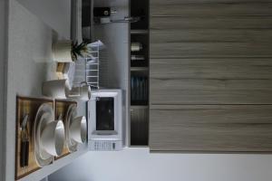 a kitchen with wooden cabinets and a microwave at Inara 2 - Apartment with airport views - Zona 13 de la Ciudad de Guatemala in Estación Pamplona