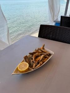 a plate of food with a slice of lemon on a table at Villa art colony in Ohrid