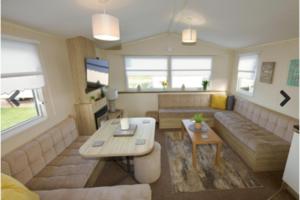 a living room with a couch and a table at Lyons Robinhood - 3 bedrooms in Rhyl