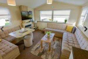 a living room with a couch and a table at Lyons Robinhood - 3 bedrooms in Rhyl