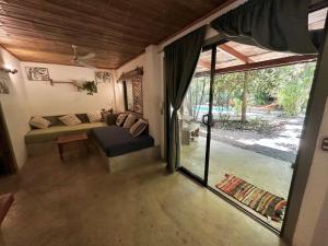 a living room with a couch and a sliding glass door at Anam Apartments in Santa Teresa Beach +57 photos