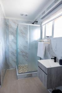 a bathroom with a shower and a sink at Towny Lodge in Kokstad