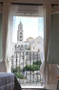Un dormitorio con una ventana con vista a una iglesia. en Roseus La Casa Vacanze nei Sassi, en Matera