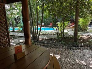 a wooden table in front of a swimming pool at Anam Apartments in Santa Teresa Beach